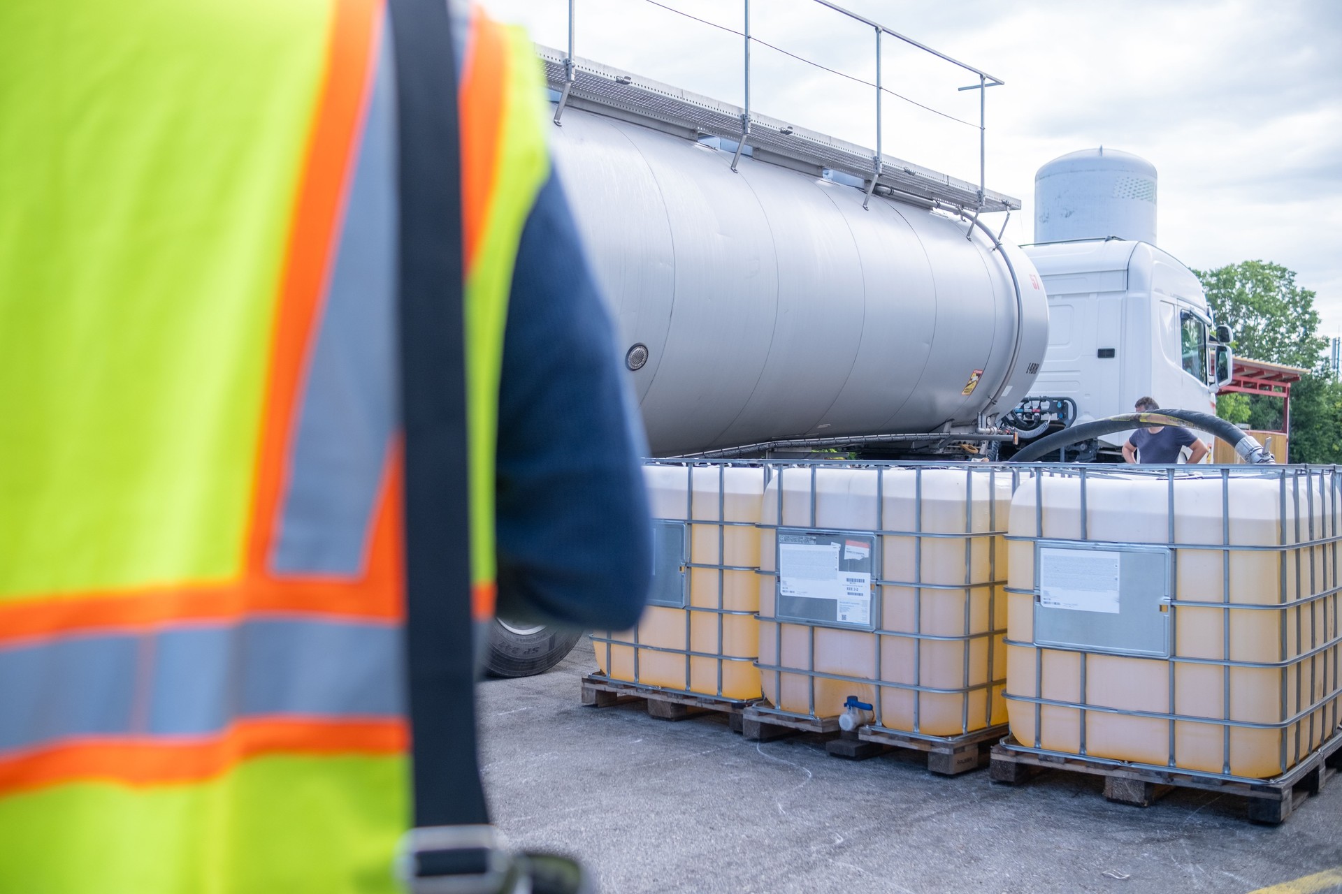 An engineer accepts a tanker vehicle with lubricants and controls the transfer into a 1000-liter IBC bulk container.